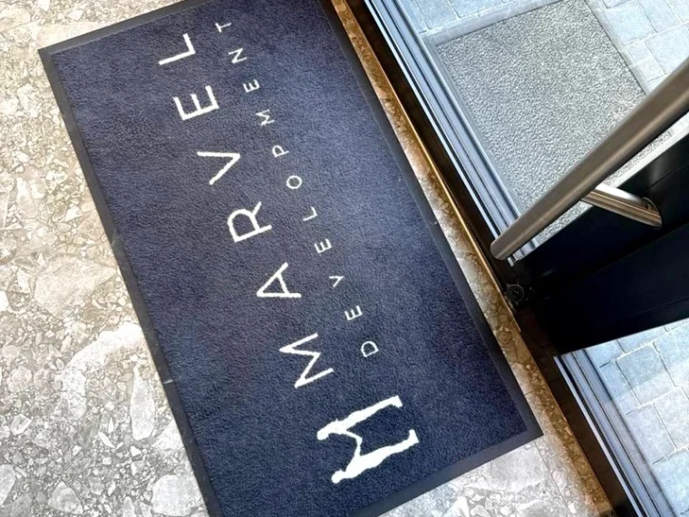 Felpudo con logotipo Marvel junto a una puerta