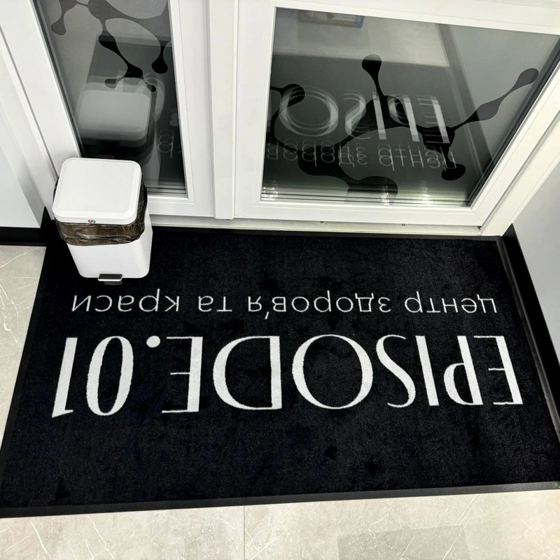 Felpudo negro con texto blanco para una entrada
