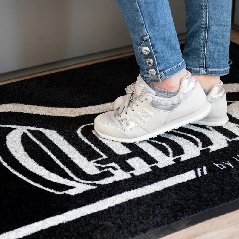 Felpudo con logotipo blanco en uso