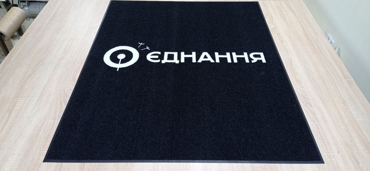 Felpudo negro de gran formato con logotipo blanco